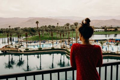 Woman waking up drinking coffee from her balcony at a palm springs resort