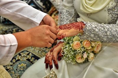 High angle view of man wearing ring to woman during wedding ceremony