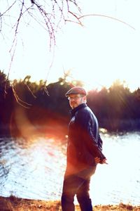 Man standing by tree against sky during sunset