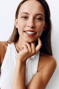 Portrait of young woman against white background