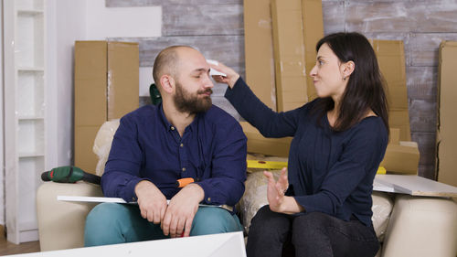 Smiling woman wiping husbands face