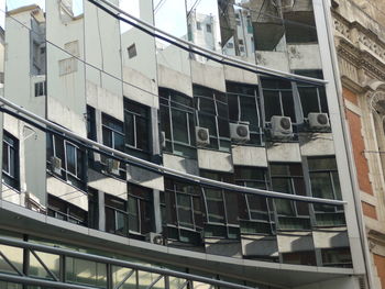 Buildings against blue sky seen through balcony