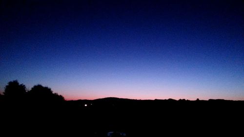 Silhouette of mountain against blue sky