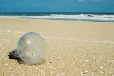 Close-up of light bulb on beach