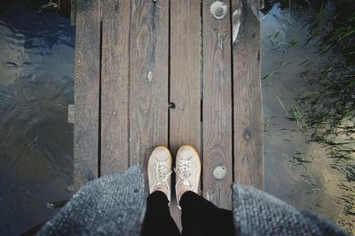 Low section of woman standing on boardwalk