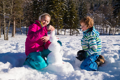 Full length of girl sitting on snow