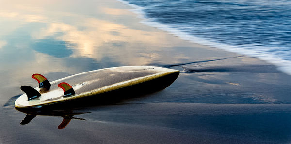 High angle view of upside down surfboard of shore at beach