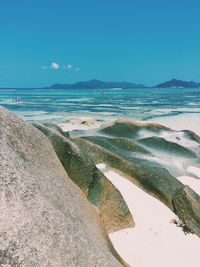 Scenic view of beach against clear blue sky