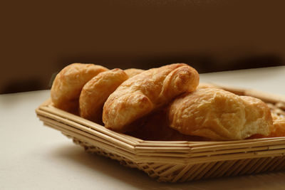 Close-up of baked breads in straw tray on table