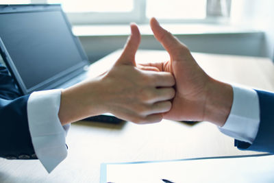 Midsection of man using mobile phone on table