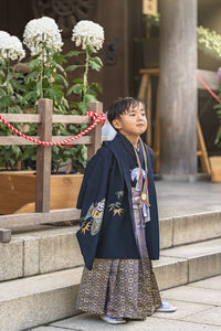 Full length of boy standing by building