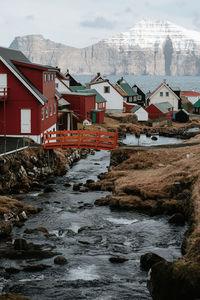 River amidst buildings against sky during winter