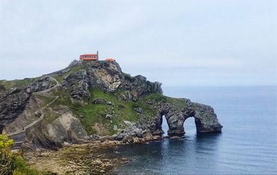 Rock formations by sea against sky