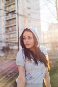 Close-up of woman wearing hooded shirt standing in city