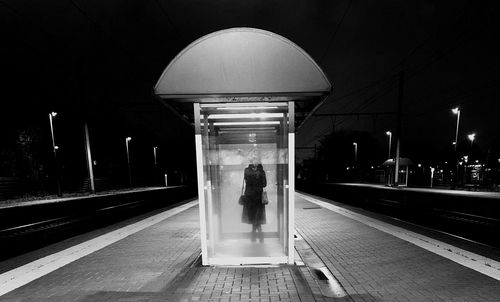 Rear view of illuminated railroad station platform at night