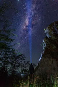 A man standing under a sunny milkyway during a clear night sky