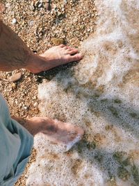 Low section of person standing in water