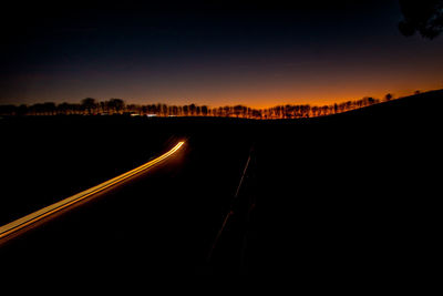 Silhouette road against sky at night