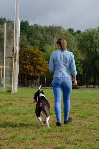 Rear view of woman with dog on field