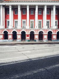 Empty road by buildings in city