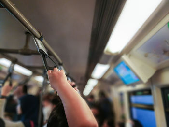 Close-up of hands holding people in bus