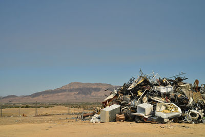 Abandoned truck on field against clear blue sky