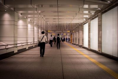 Rear view of people walking in corridor