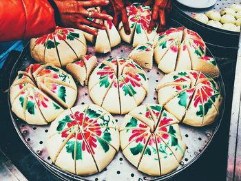 Cropped hands by desserts in tray for sale at market