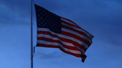 Low angle view of american flag against blue sky