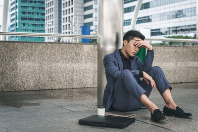 Full length of man sitting in city