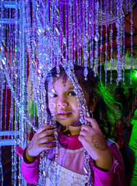 Portrait of cute girl holding decorations at night