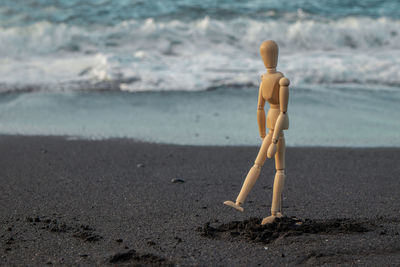 Figurine on sand at beach