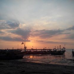 Scenic view of sea against cloudy sky during sunset