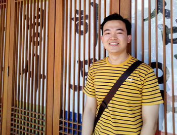 Portrait of smiling young man standing at home