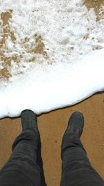 Low section of person standing on tiled floor