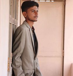 Young man standing against wall