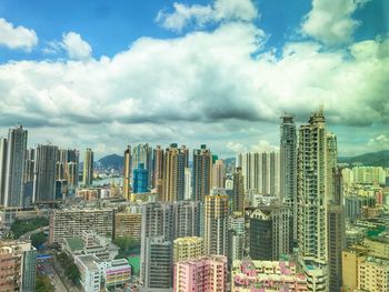 Aerial view of cityscape against cloudy sky