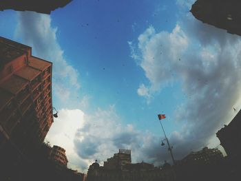 Low angle view of buildings against cloudy sky