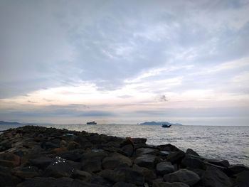 Rocks on sea shore against sky