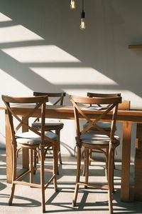 Empty chairs and table against wall