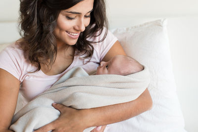 Young woman smiling while relaxing on bed