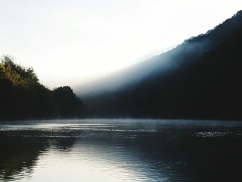 View of calm lake in foggy weather