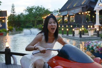 Portrait of young woman shouting while sitting on ride