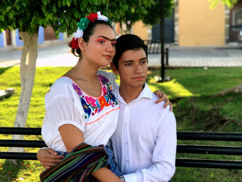 Portrait of young couple sitting outdoors