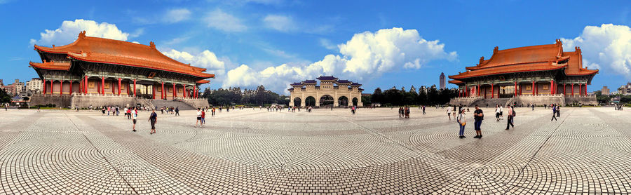 Group of people in traditional building against sky