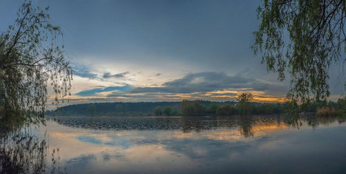 Scenic view of lake against sky at sunset