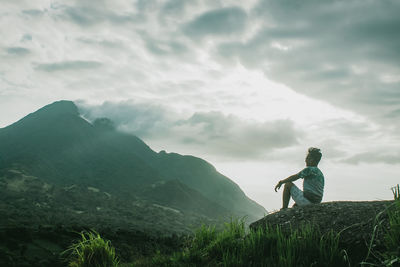 Man standing on mountain against sky