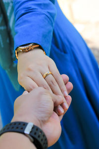 Midsection of couple holding hands