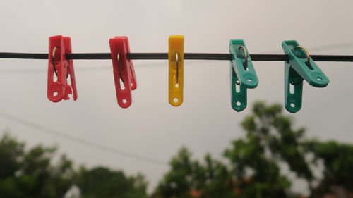 Low angle view of clothespins hanging on rope