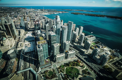 High angle view of modern buildings by sea against sky